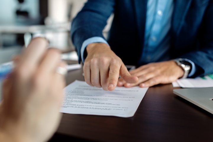 Consultor apontando o campo de assinatura do contrato
