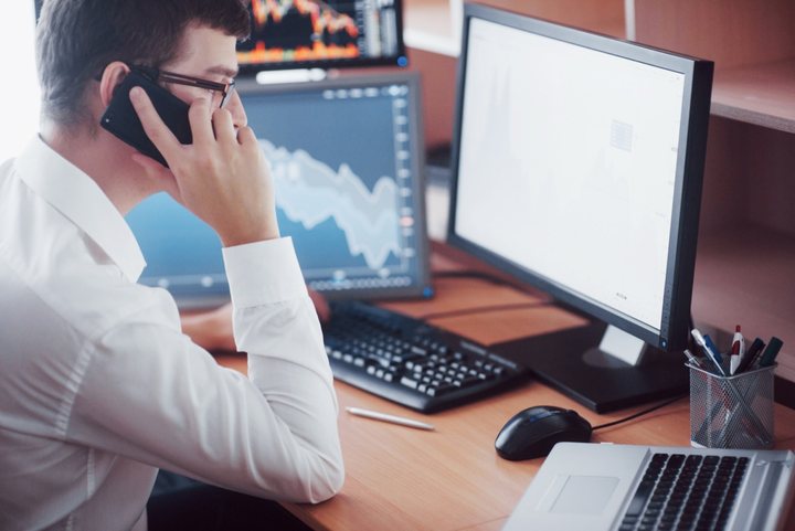 Analista acompanhando dados em monitores